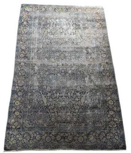 A Persian rug, with an allover design of flowers, leaves, birds, etc., on a beige ground, one...