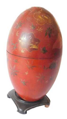 A Chinese red lacquer egg shaped box, decorated with panels of storks, landscapes, leaves, etc.,...