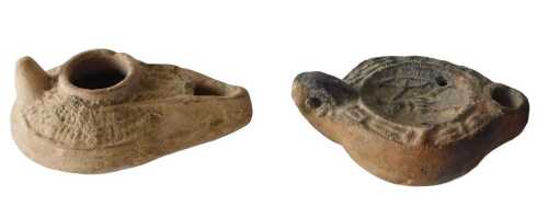 A Roman style terracotta oil lamp, decorated with a figure, and a similar Byzantine style oil...