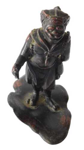An Oriental bronze figure of a God, with animal like face, standing on a lotus leaf, 10cm high....