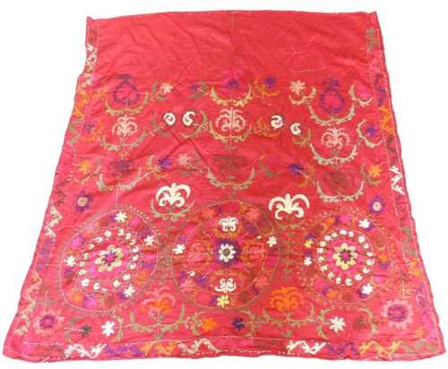 An Eastern suzani, decorated with three roundels, in pink, white, green, gold, blue, orange, etc....