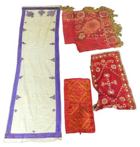A collection of Eastern fabrics, to include two embroidered suzani fragments, a cushion cover,...