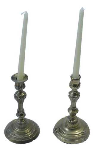 A pair of 19thC gilt brass rococo candlesticks, each with urn dish holders, raised on inverted...