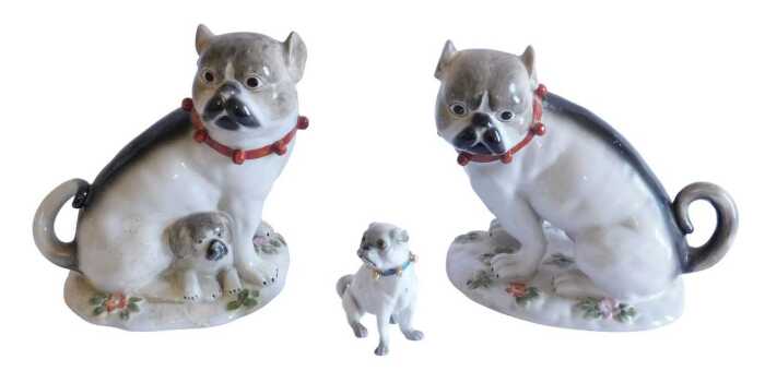 A pair of Continental Meissen style porcelain pug dogs groups, the first with standing dog and...