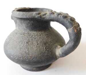 A Continental black glazed terracotta jug, the border and handle decorated with roundels, 15cm... - 6