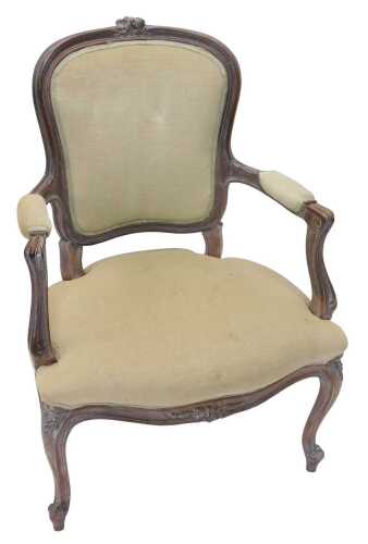 An early 20thC French carved walnut fauteuil, with shaped spoon back, centred by carved flowers,...