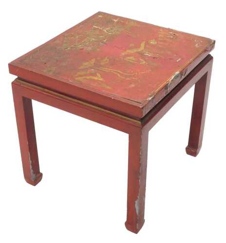 An early 20thC Chinese red lacquered table, with gilt highlights, profusely decorated with trees...