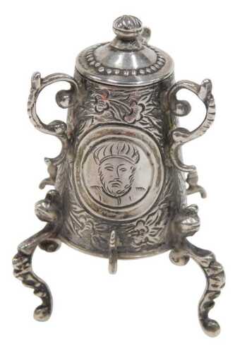 A 19thC miniature model of a samovar, heavily chased with panels set with figures on scroll feet,...