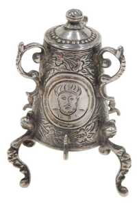 A 19thC miniature model of a samovar, heavily chased with panels set with figures on scroll feet,...