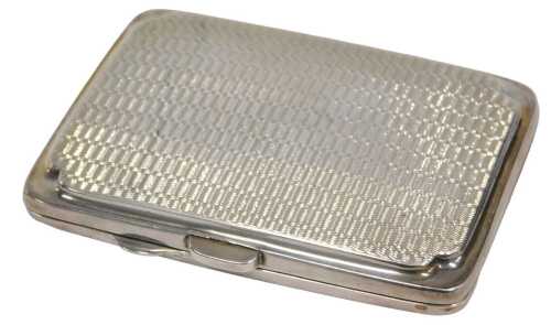 A George V silver cigarette or card case, of oblong form, with engine turned body and silver...