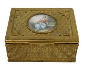 A 20thC gilt metal trinket box, of rectangular form, the hinged lid hand painted with a figure...