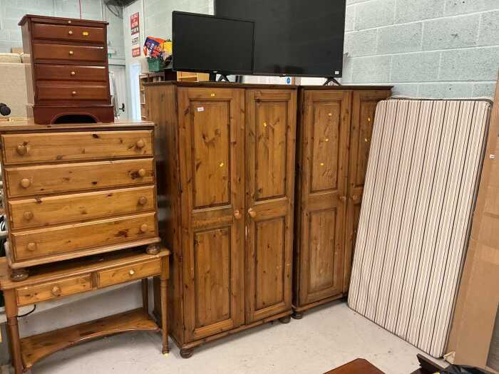 V - A pine bedroom suite, comprising two double door wardrobes, chest of four long drawers, side...