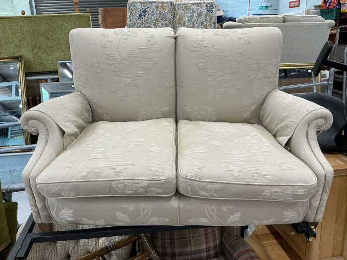A two seater settee, on oak frame, with square tapering legs, on castors.