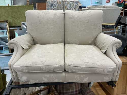A two seater settee, on oak frame, with square tapering legs, on castors.