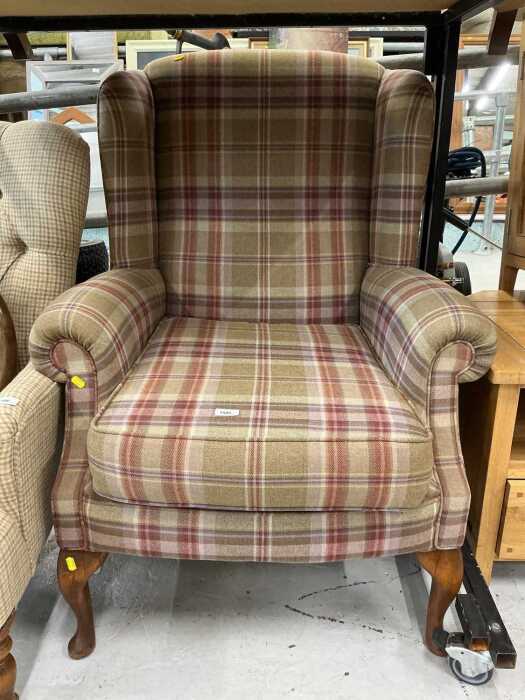 An oak wing chair, in chequered material.
