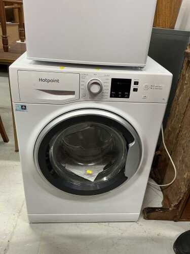 A Hotpoint 7kg Anti Stain washing machine, with some paperwork.