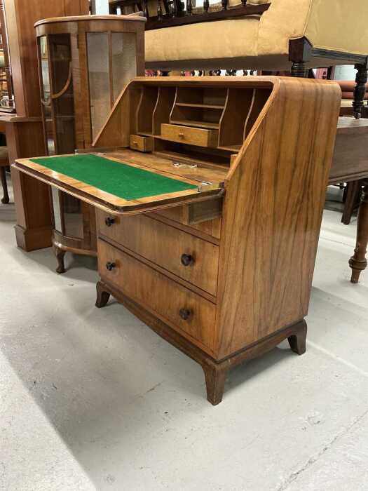 A mid 20thC walnut bureau, the quarter veneered fall revealing a fitted interior with loafers,...