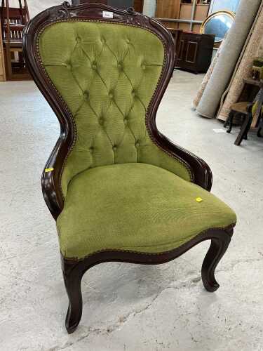 A spoonback nursing chair, upholstered in green studded material. The upholstery in this lot...