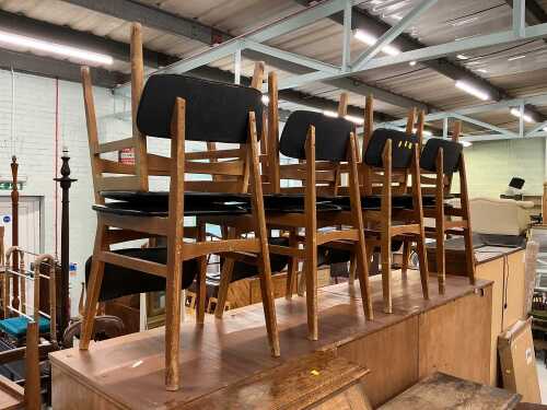 A set of eight teak dining chairs, each with leather backs and seats. The upholstery in this lot...