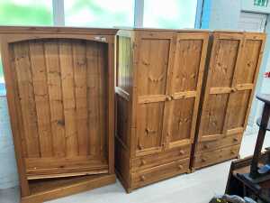 A pine open bookcase, and two pine double door wardrobes.