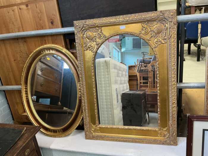 A pair of gilt wooden framed mirrors, one of decorated rectangular form enclosing an arch shaped...
