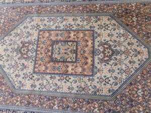 A 20th machine woven rug, the outer field with a geometric floral pattern, in cream, the inner... - 2