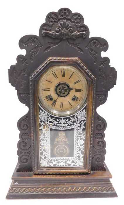 A late 19thC oak cased American gingerbread clock, the 13cm diameter Roman numeric dial marked...