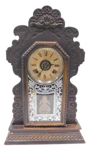 A late 19thC oak cased American gingerbread clock, the 13cm diameter Roman numeric dial marked...