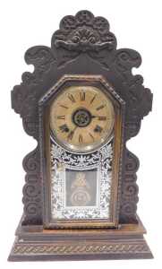 A late 19thC oak cased American gingerbread clock, the 13cm diameter Roman numeric dial marked...