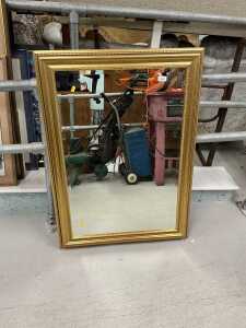 A gilt coloured hanging mirror, with bevelled glass.