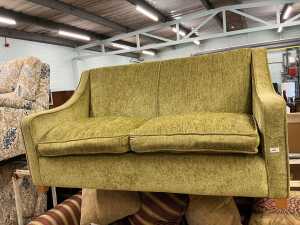 V - A DFS two seater sofa bed, in green material. Note: VAT is payable on the hammer price of this...