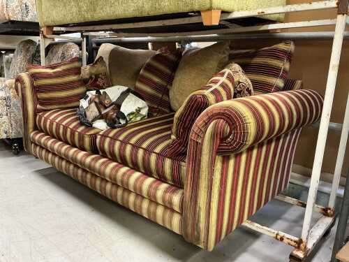 V - A three seater settee, in Regency style striped material, with cushions. Note: VAT is payable on...