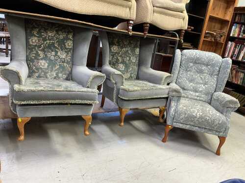 Two Parker Knoll wing armchairs, in floral material, and a further wing armchair. The upholstery...