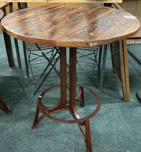 V - A wrought iron framed industrial style pub table, of circular form with wooden top. With the...