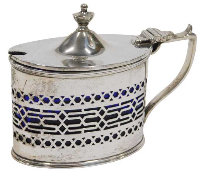 A George V silver mustard pot, of oval form, with urn finial, thumb mould handle and part...