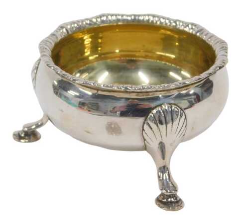 A George VI silver three footed salt, with shaped rim, silver gilt interior, plain circular body...