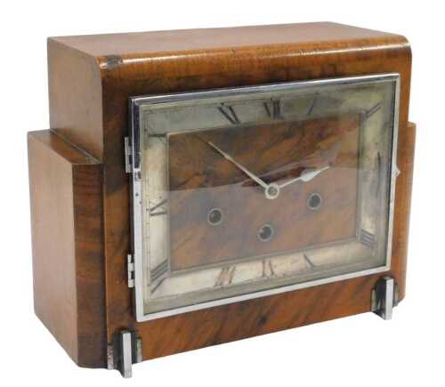 An Art Deco mid-20thC walnut cased chiming mantel clock, the shaped case holding a 22cm Roman...