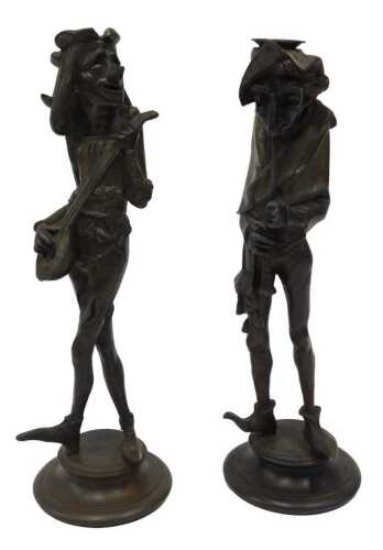 A pair of French spelter candlestick caricature figures, of medieval musicians, each in standing...