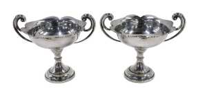 A pair of late Edward VII silver bonbon dishes, each with scroll handles, flared floral rims,...
