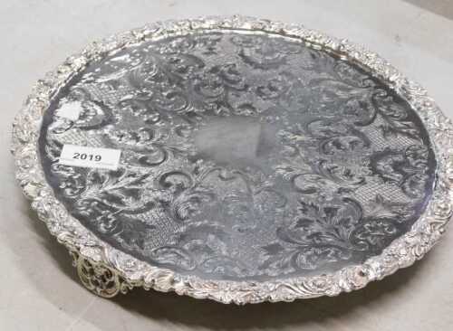 A late 19thC silver plated waiter, the centre chased with scrolls and flowers, the border raised...