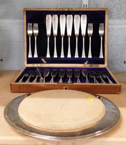 A silver plated and wooden bread board, and a cased canteen of fish eaters.