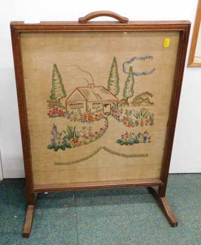 An oak framed fire screen, with embroidered centre.