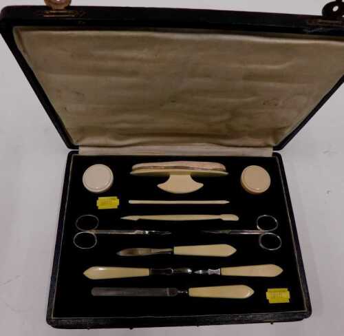 An early 20thC vanity case, containing various tools, etc., with faux ivorine handled implements.