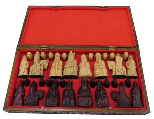 A 20thC wooden chess board, with heavily carved board, 44cm wide, hinging to reveal a set of...