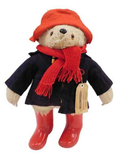 A 1990s official plush jointed Paddington Bear, in red PV wellingtons, blue duffel jacket, red...