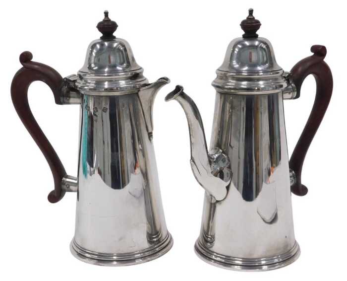 A pair of Elizabeth II silver water jugs, each with domed lids, shaped ear handles and plain...