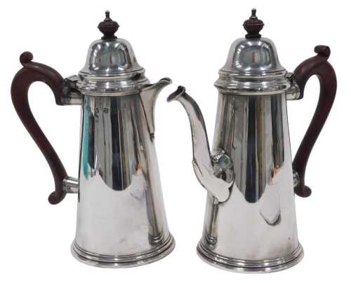 A pair of Elizabeth II silver water jugs, each with domed lids, shaped ear handles and plain...