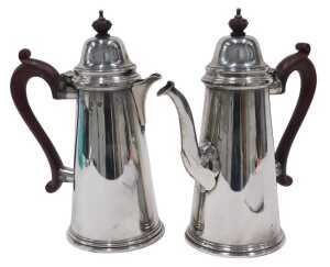 A pair of Elizabeth II silver water jugs, each with domed lids, shaped ear handles and plain...