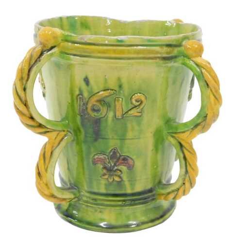 A late 19thC Majolica style Castle Hedingham pottery four handled vessel, by Bingham, in green...