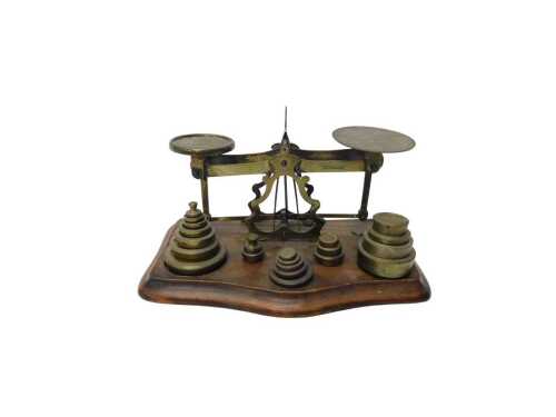 An early 20thC brass table scale, with oval and circular pans, on a serpentine base, with...